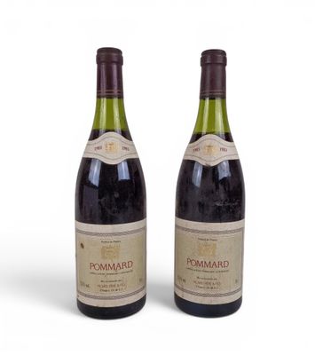 two bottles of wine sitting next to each other on a white surface