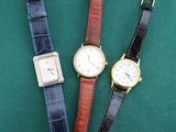 trois montres de couleurs différentes posées sur une surface verte