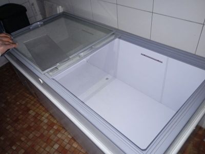une personne ouvrant un congélateur dans une cuisine
