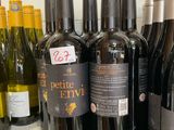bottles of wine are lined up on a shelf in a store