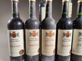 six bottles of wine are lined up in a row on a table
