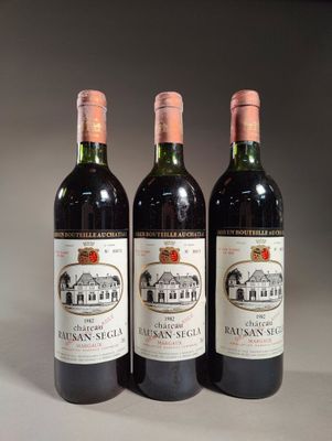 trois bouteilles de vin posées sur une table l'une à côté de l'autre