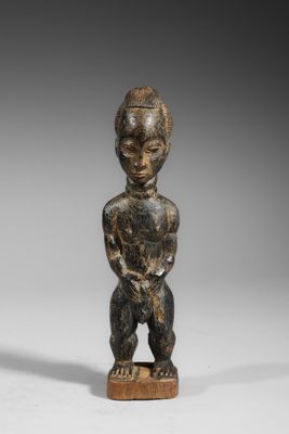 une petite statue en bois représentant un homme coiffé d'un chapeau