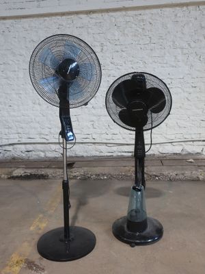 deux ventilateurs noirs posés l'un sur l'autre dans un parking