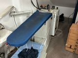 an ironing board sitting on top of a bed in a room