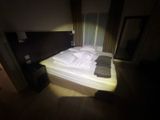 a bed in a dark room with a light shining on it