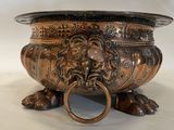 a large metal bowl with a lion head on it