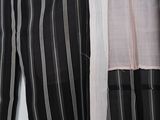two black and white striped pants hanging on a white wall