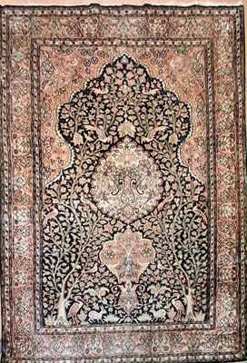 an antique persian rug with a floral design on a black ground