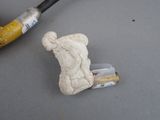 a small statue of a man holding a pipe next to a pipe cutter