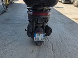 une moto garée sur un parking, avec une plaque d'immatriculation à l'arrière