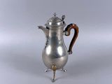 a silver coffee pot with a wooden handle on a white surface