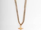 a gold cross necklace with a chain on a mannequin mannequin mannequin mannequin mannequin mannequin mannequin manne
