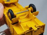 a person holding a yellow toy truck in their hand