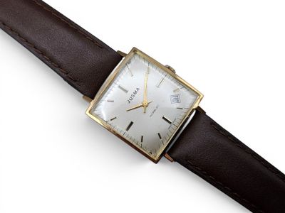 une image d'un gros plan d'une montre-bracelet sur une surface blanche