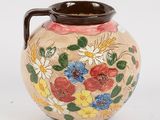 a vase with flowers painted on it sitting on a table
