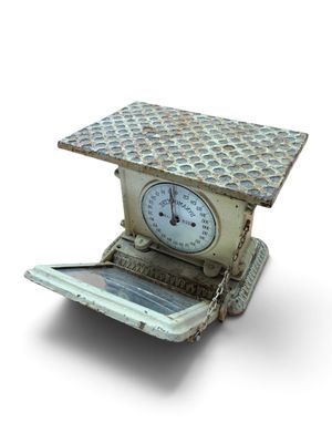 a small scale with a clock on top of it