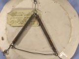 a white plate with a triangle on it hanging on a chain