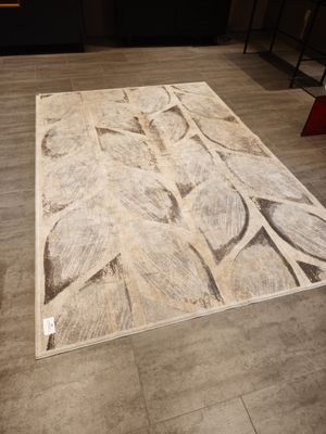 beige and white area rug with leaves on it in a room