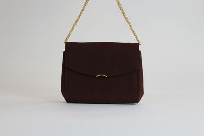 un sac à main marron dont la poignée est ornée d'une chaîne dorée