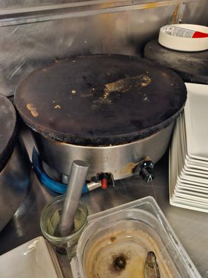 une casserole sale posée sur la cuisinière dans une cuisine