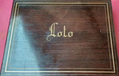 une vieille boîte en bois sur laquelle est inscrit le mot « Lola »