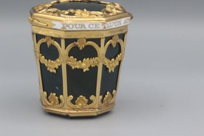 un récipient noir et doré orné d'un motif doré