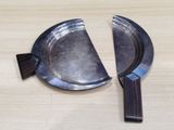 deux morceaux de métal posés sur une table, avec un pinceau