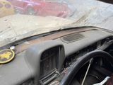 a dirty dashboard of a car with a sticker on it