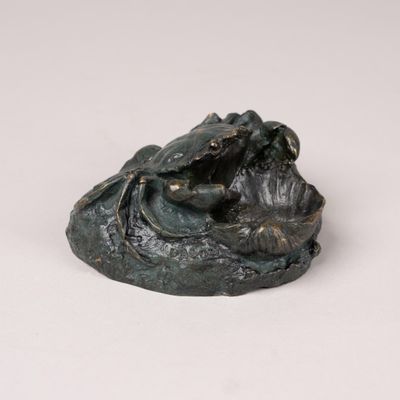 an image of a statue of a frog sitting on top of a rock