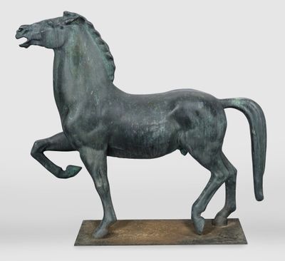 statue d'un cheval au galop posée sur un socle en bois, sur fond blanc