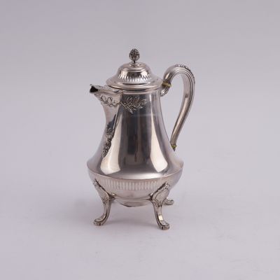 an antique silver coffee pot on a stand on a white background