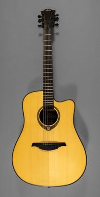 a yellow acoustic guitar hanging on a gray wall