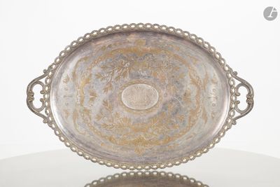 un plateau en argent orné d'un motif, posé sur une table