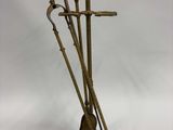 une photo d'une sculpture en bronze représentant trois balais posés sur un socle