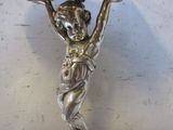 une statue représentant une femme tenant un coquillage, posée sur une table