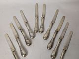 eight silverplated knives and spoons arranged in the shape of a circle