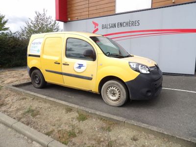 une petite camionnette jaune garée devant un immeuble