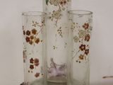 three glass vases with flowers on them on a table