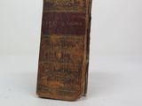 an old book sitting on top of a white table next to a white wall