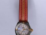 une montre montée sur un bracelet en cuir rouge
