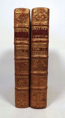 pair of antique books on a white surface with a white background
