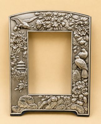 un cadre photo en métal orné d'oiseaux et de fleurs sur fond beige