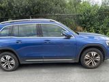 the blue suv is parked in a parking lot next to a black car