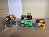 trois tracteurs miniatures posés les uns à côté des autres sur une table