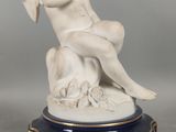 une statue représentant un ange assis sur une table