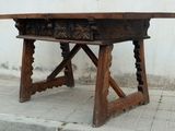 a wooden table with carvings on it sitting on a sidewalk