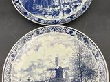 deux assiettes bleues et blanches sur lesquelles est représenté un village