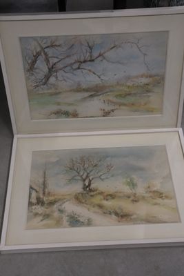 two paintings of trees in a white box on a table