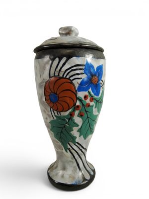 a vase with a flower design on it on a white surface